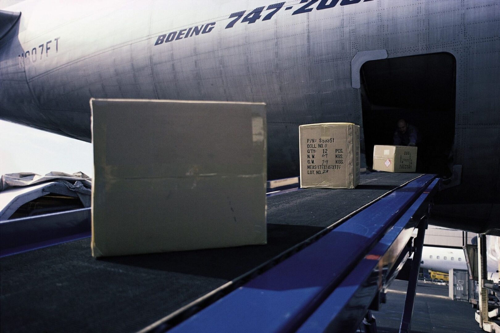 A box is on the conveyor belt of an airplane.